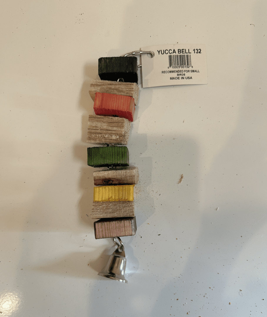 A stack of colorful Yucca Bell wooden blocks hanging on a white wall.